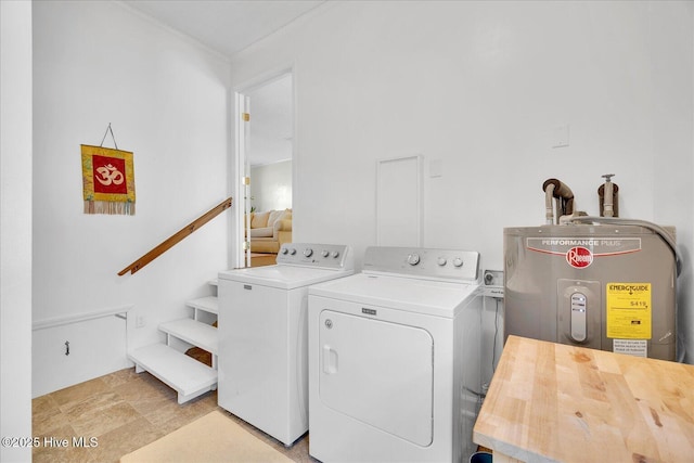 clothes washing area with washing machine and dryer, laundry area, and water heater