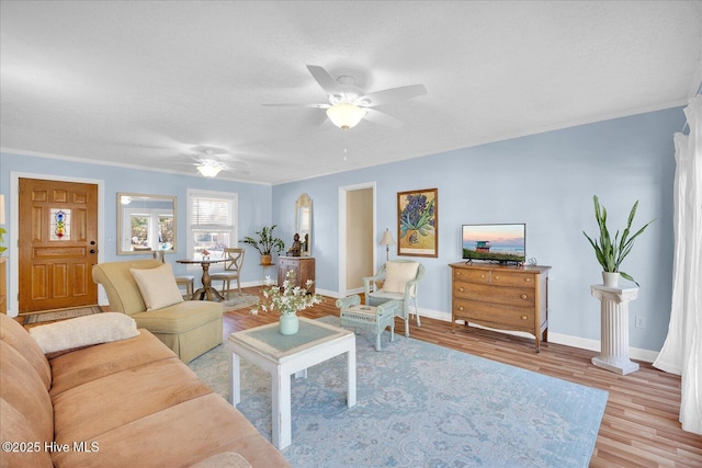 living room with a textured ceiling, ceiling fan, wood finished floors, and baseboards