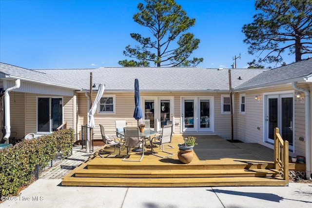 exterior space with a shingled roof, french doors, and a wooden deck