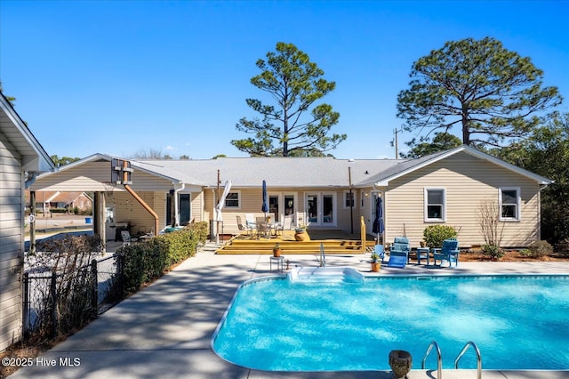 pool featuring french doors, a patio area, and a wooden deck