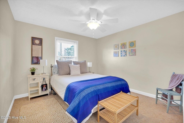 bedroom with ceiling fan, a textured ceiling, light colored carpet, and baseboards