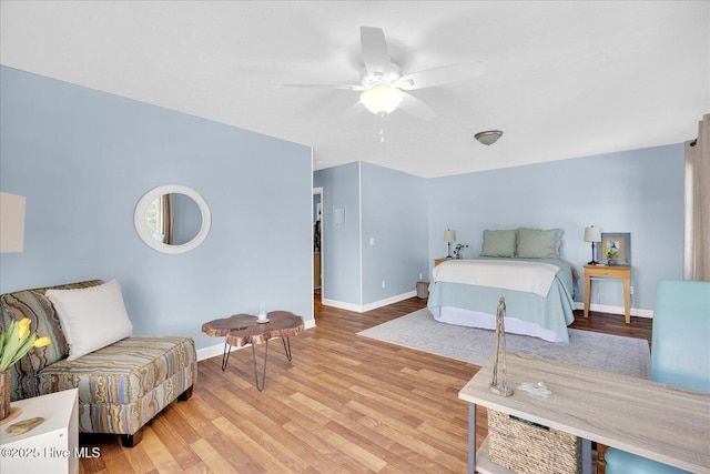 bedroom with light wood-style floors, ceiling fan, and baseboards