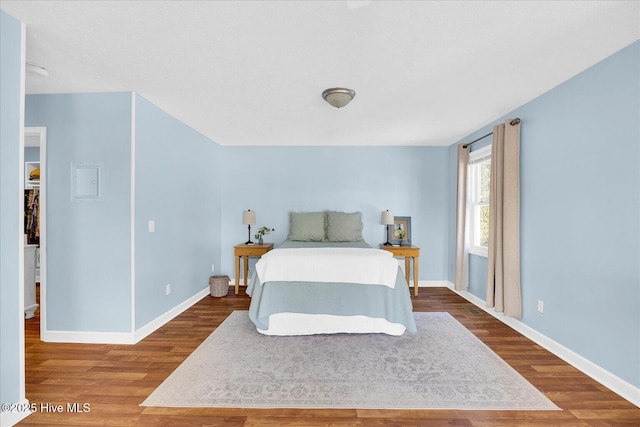 bedroom with baseboards and wood finished floors