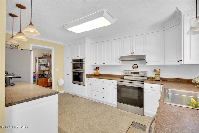 kitchen featuring white cabinets, dark countertops, appliances with stainless steel finishes, under cabinet range hood, and a sink