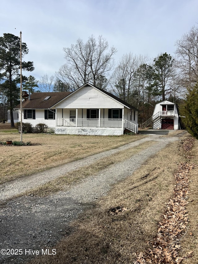 view of front of property featuring covered porch and dirt driveway