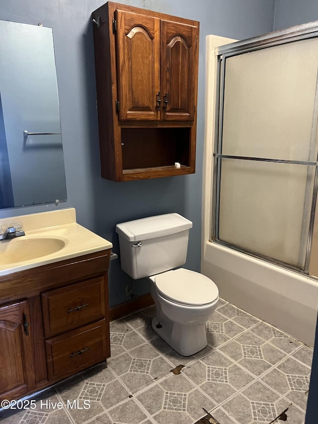 bathroom with toilet, tile patterned floors, bath / shower combo with glass door, and vanity