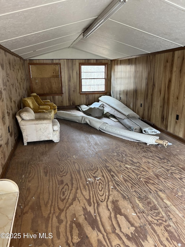 bonus room featuring lofted ceiling and wood walls