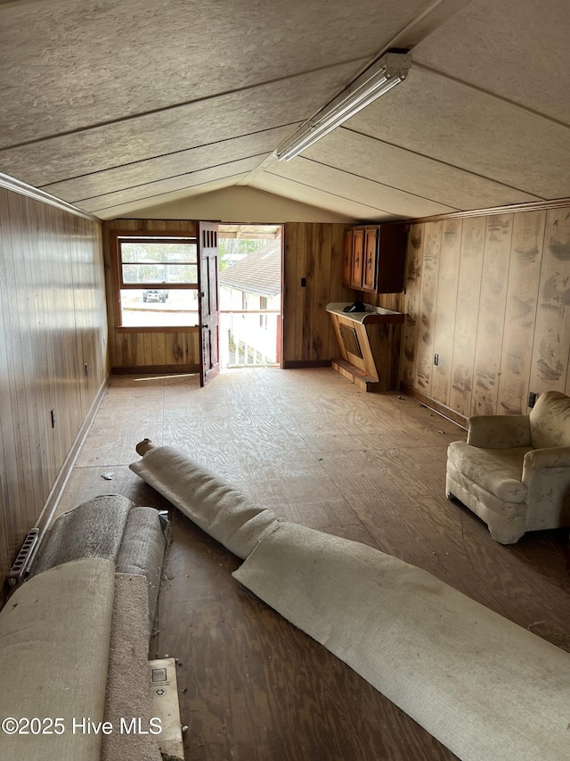 unfurnished living room with lofted ceiling and wood walls