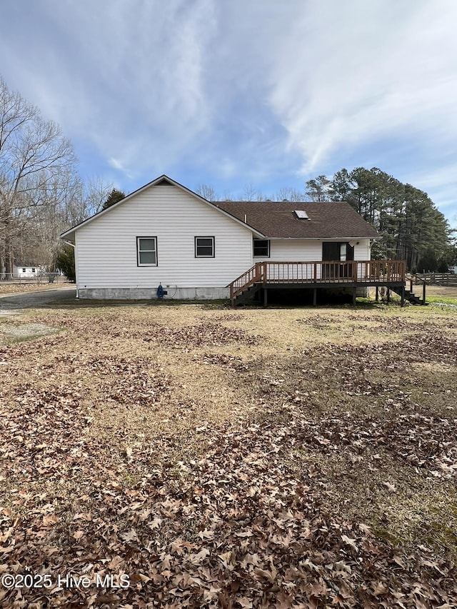 rear view of property featuring a wooden deck