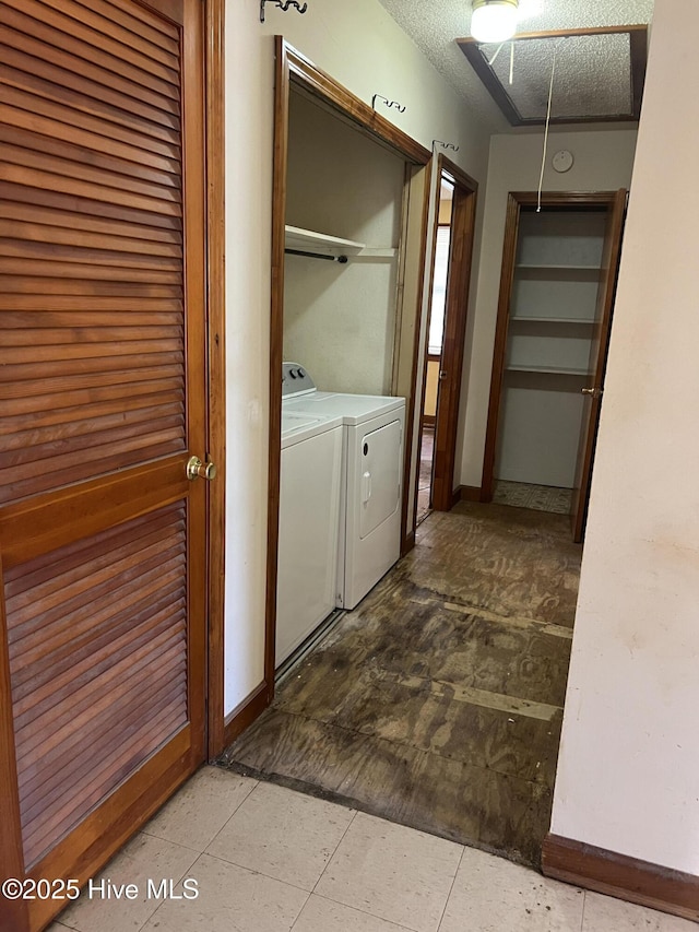 washroom with attic access, baseboards, washer and clothes dryer, and a textured ceiling