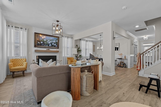 living room featuring light wood-type flooring and an inviting chandelier