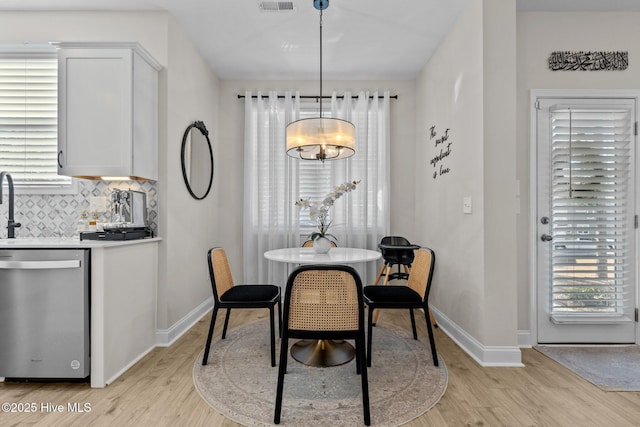 dining space with light hardwood / wood-style flooring and a chandelier