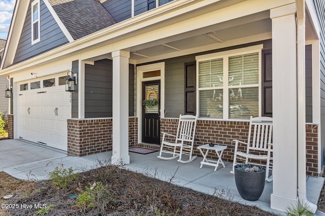 view of exterior entry with a garage and a porch