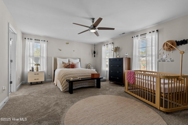 bedroom featuring ceiling fan, multiple windows, and carpet