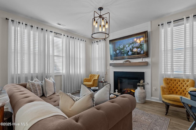 living room featuring light hardwood / wood-style floors and a notable chandelier