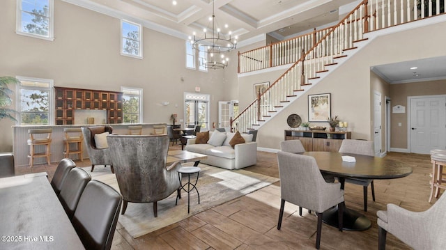 living room with coffered ceiling, beam ceiling, crown molding, and light hardwood / wood-style flooring