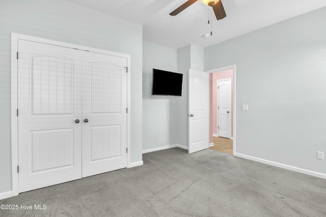 unfurnished bedroom with ceiling fan, a closet, and light colored carpet