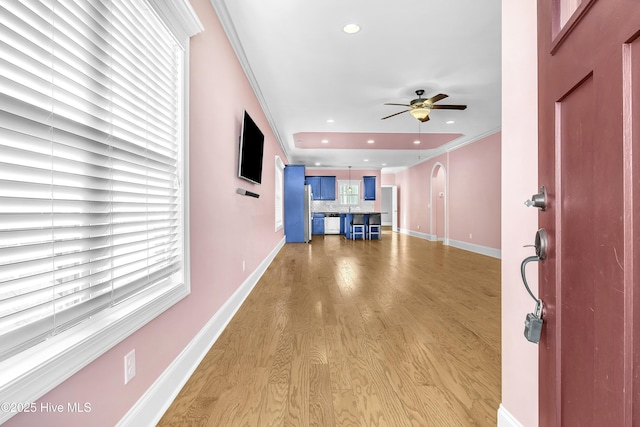 entrance foyer with light hardwood / wood-style flooring, ceiling fan, and ornamental molding