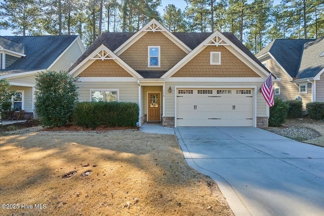 craftsman-style house with a garage, concrete driveway, and stone siding