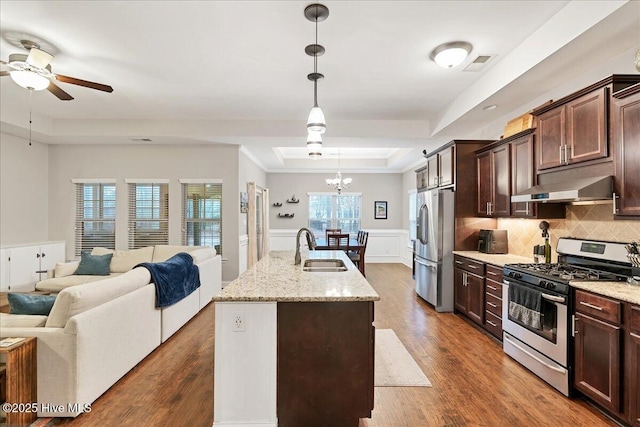 kitchen with visible vents, a tray ceiling, stainless steel appliances, under cabinet range hood, and a sink