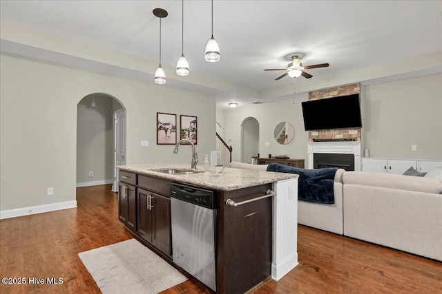 kitchen with dishwasher, dark wood-type flooring, arched walkways, and a sink