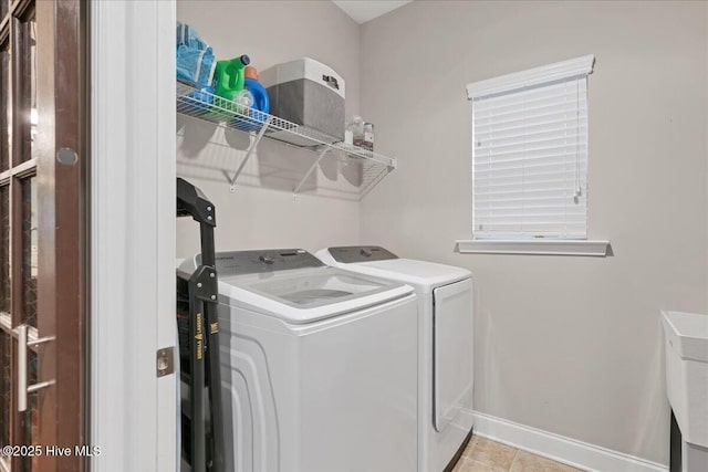 laundry room with laundry area, tile patterned floors, baseboards, and washing machine and clothes dryer