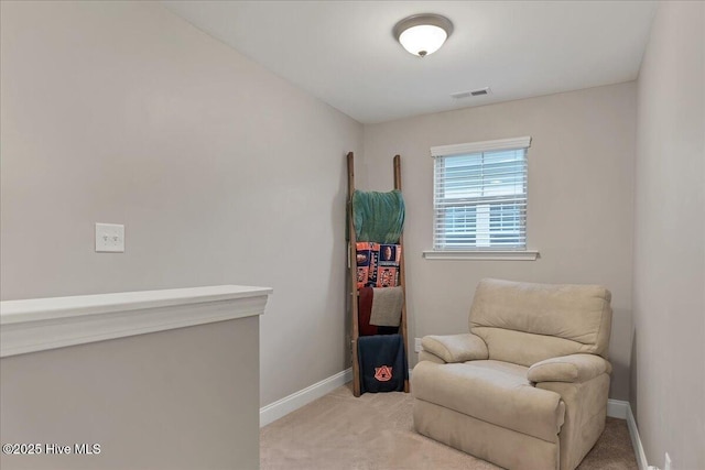 sitting room featuring baseboards, visible vents, and light colored carpet