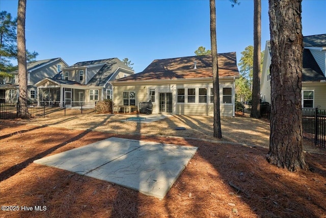 rear view of property featuring fence and a patio