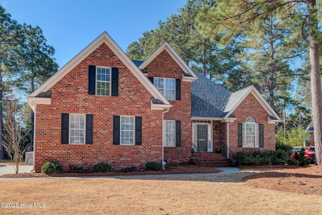 traditional home with a shingled roof and brick siding