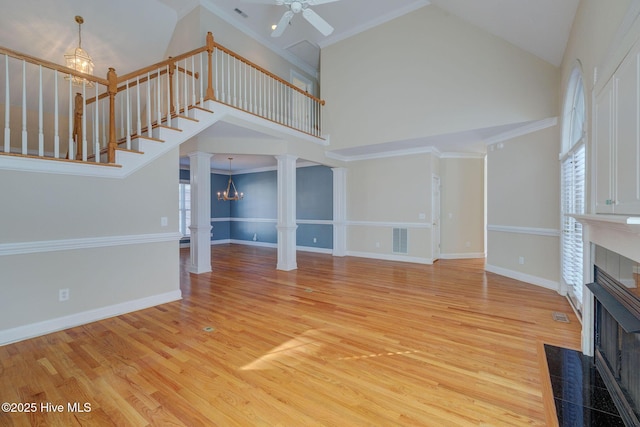 unfurnished living room with ornate columns, visible vents, light wood-style flooring, and a tiled fireplace