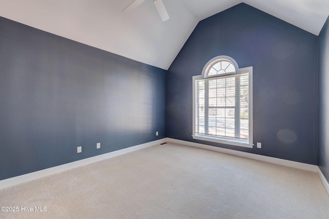 carpeted spare room featuring lofted ceiling, ceiling fan, and baseboards