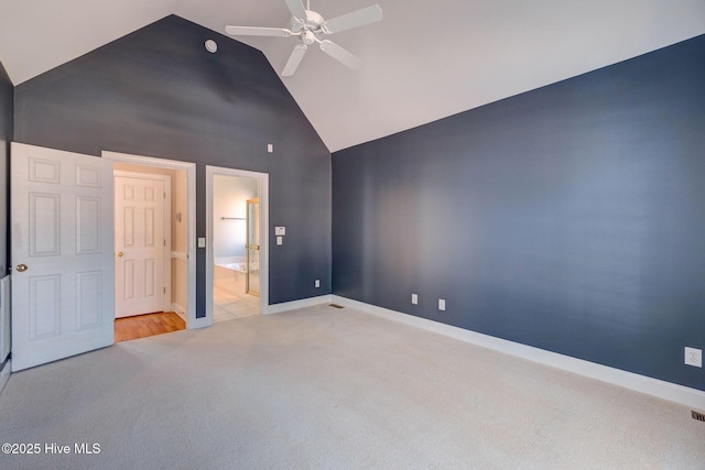 unfurnished bedroom with high vaulted ceiling, connected bathroom, carpet floors, a ceiling fan, and baseboards