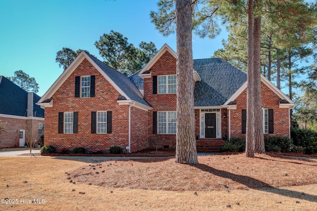 traditional-style home with brick siding and roof with shingles