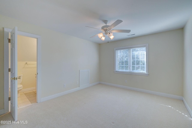 unfurnished room featuring carpet floors, visible vents, baseboards, and a ceiling fan