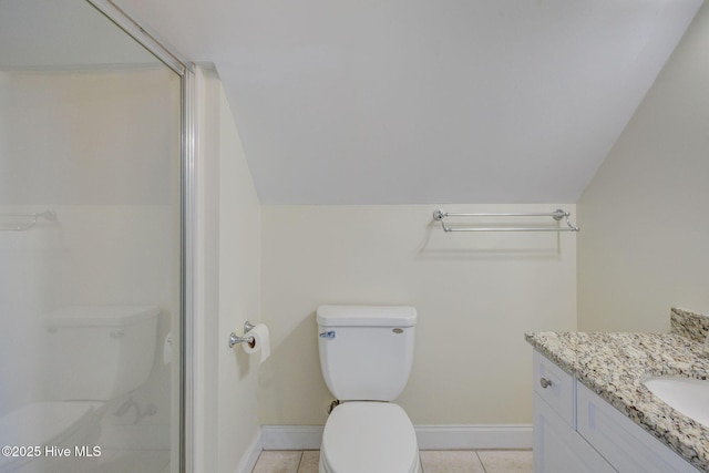 bathroom with toilet, tile patterned flooring, baseboards, and vaulted ceiling