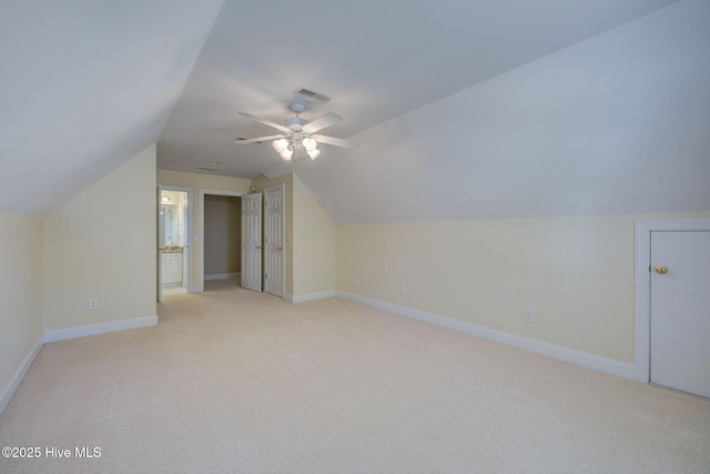 additional living space featuring light carpet, baseboards, visible vents, and vaulted ceiling