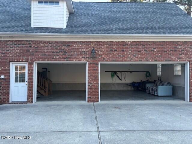 garage featuring concrete driveway