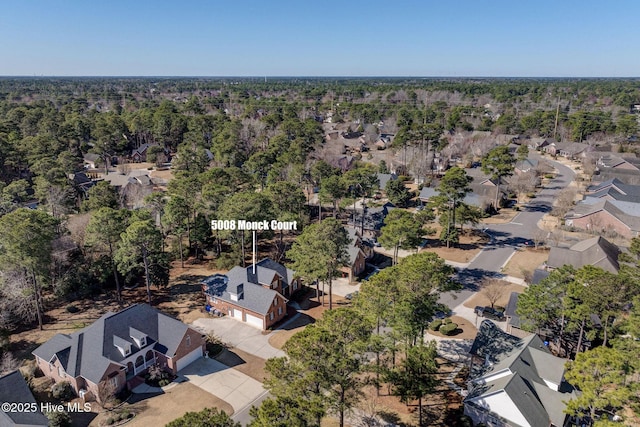 drone / aerial view with a residential view and a view of trees