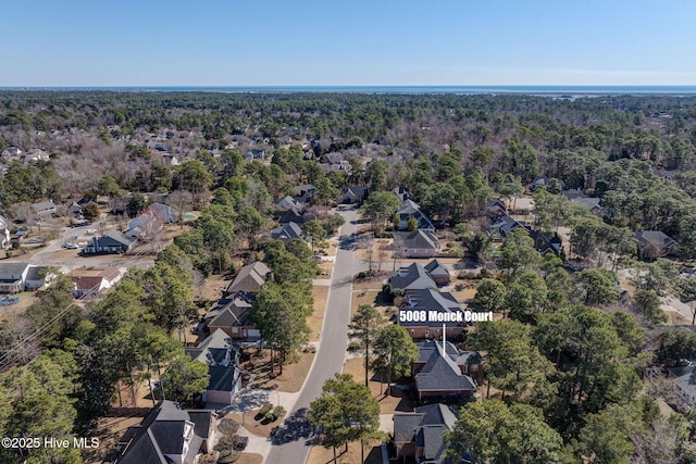 drone / aerial view with a wooded view and a residential view