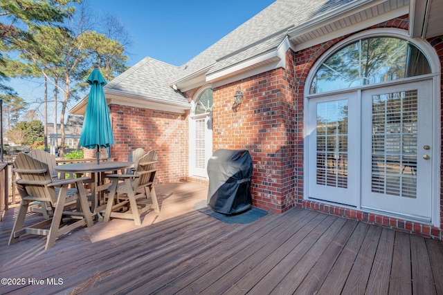 wooden terrace with grilling area and outdoor dining space