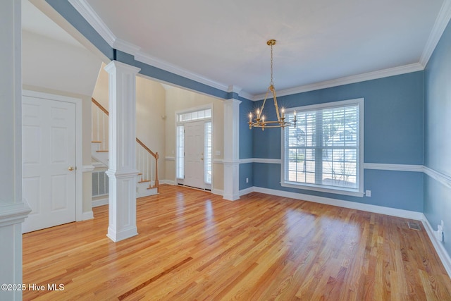 unfurnished dining area with visible vents, stairway, ornamental molding, light wood-type flooring, and ornate columns