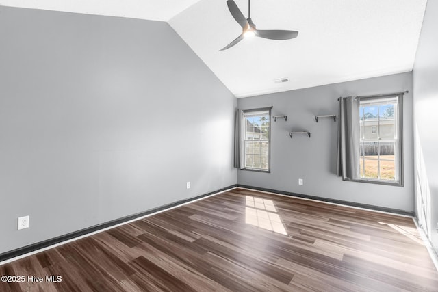 empty room featuring ceiling fan, plenty of natural light, wood-type flooring, and vaulted ceiling