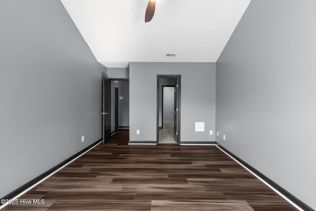 unfurnished bedroom featuring ceiling fan and dark hardwood / wood-style flooring