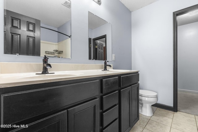 bathroom featuring vanity, toilet, and tile patterned flooring