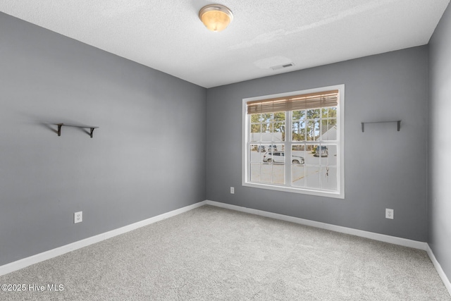 unfurnished room featuring carpet and a textured ceiling