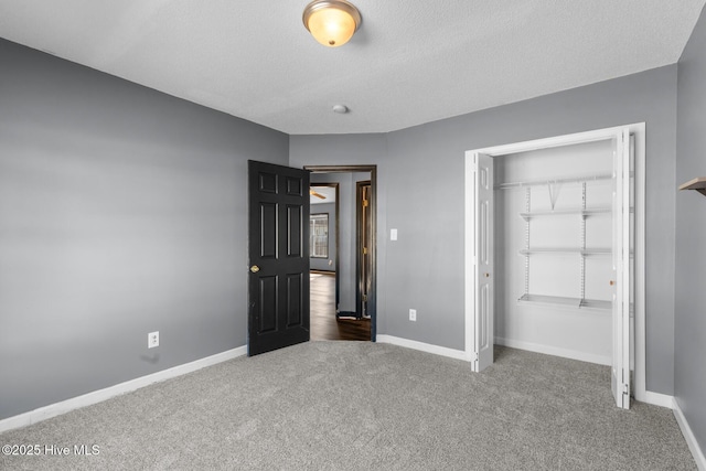 unfurnished bedroom with a closet, carpet, and a textured ceiling