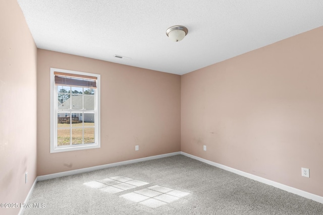 carpeted spare room featuring a textured ceiling