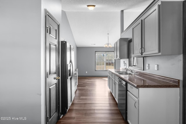 kitchen featuring sink, vaulted ceiling, stainless steel dishwasher, dark hardwood / wood-style floors, and gray cabinets