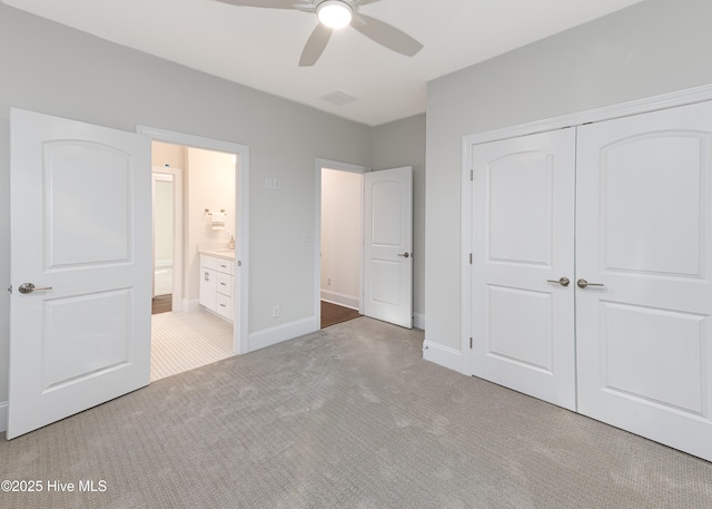 unfurnished bedroom with ceiling fan, connected bathroom, carpet flooring, and a closet