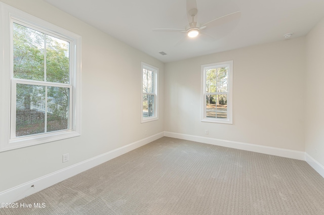 carpeted spare room with ceiling fan